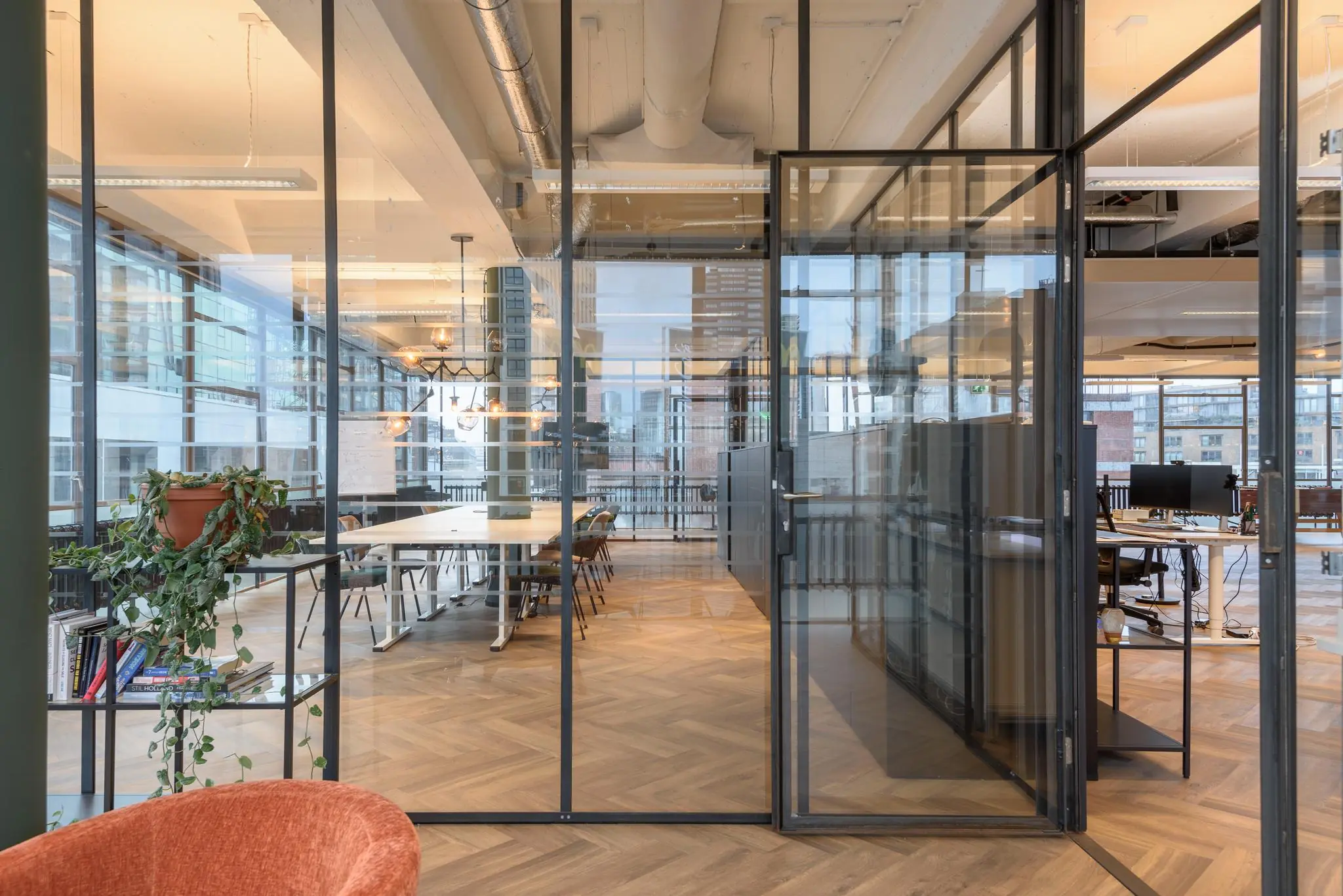 Modern kantoorinterieur aan de Vlasmarkt met glazen wanden, houten vloer en een vergaderruimte.