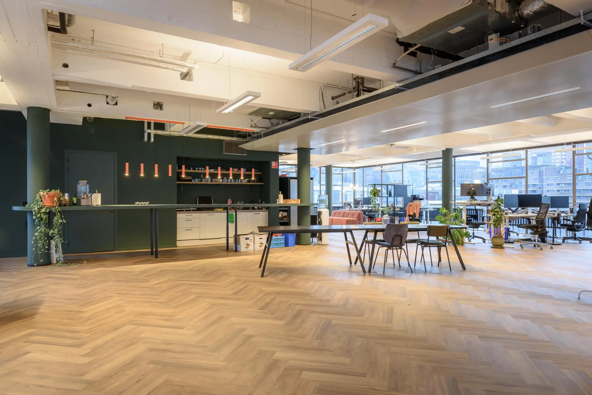 Moderne en ruime kantoorruimte aan de Vlasmarkt met open werkplekken, een lange koffietafel en veel natuurlijk licht.