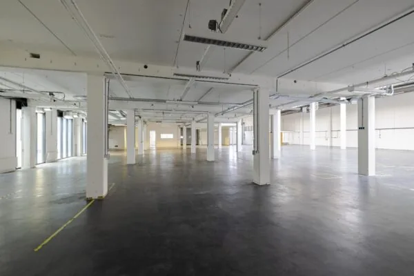 Lege industriële ruimte met witte pilaren en betonnen vloer aan de Laarderhoogtweg.