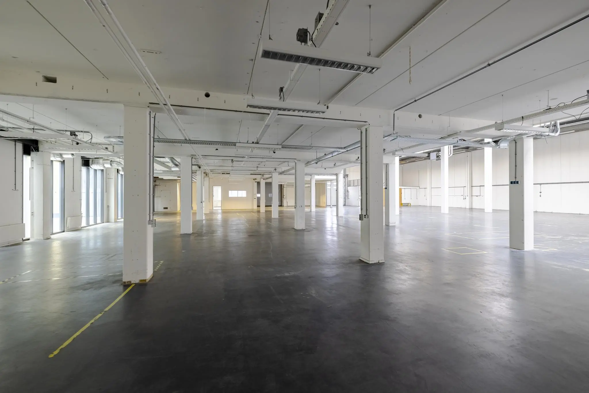 Lege industriële ruimte met witte pilaren en betonnen vloer aan de Laarderhoogtweg.