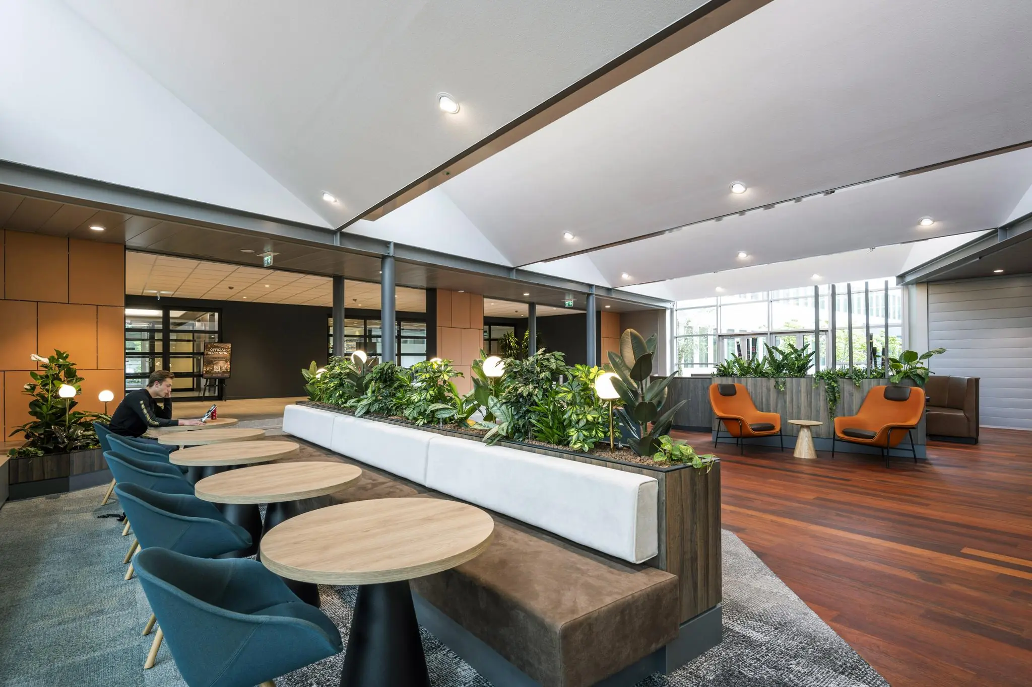 Moderne en sfeervolle lounge- en werkruimte aan de Jachthavenweg met zitgedeelte, planten en natuurlijk licht.