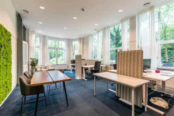 Licht en modern kantoor aan de Amersfoortsestraat met open werkplekken, grote ramen en groen uitzicht.