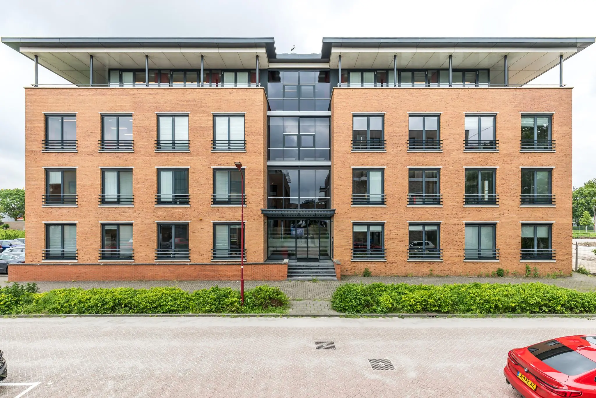 Modern kantoorpand aan de Coltbaan met een symmetrische bakstenen gevel en grote raampartijen.