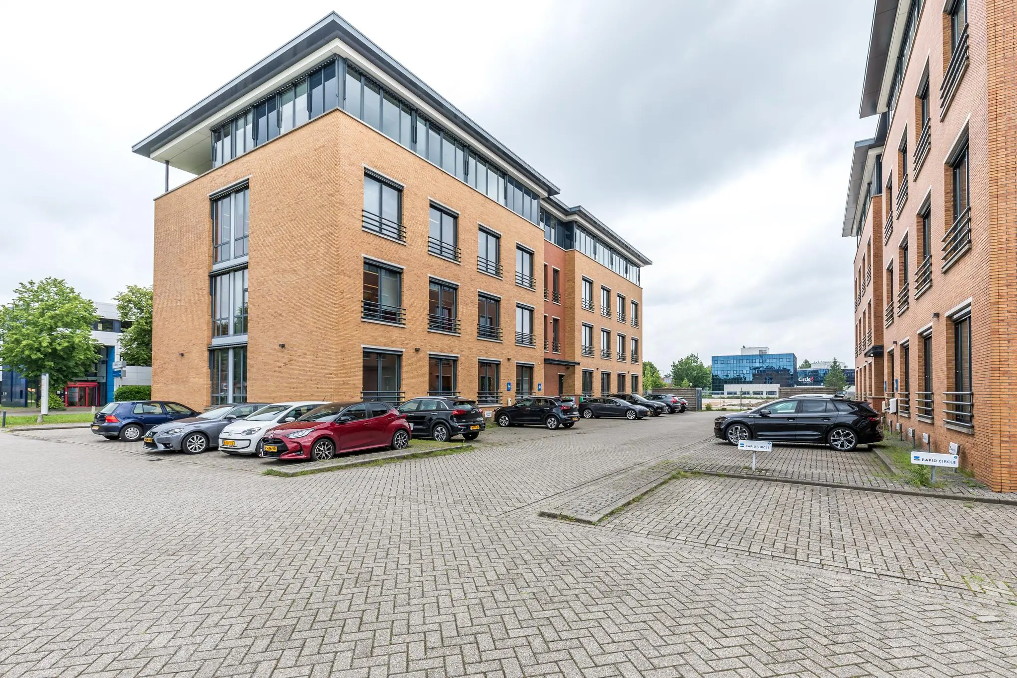 Kantoorgebouwen aan de Coltbaan met geparkeerde auto's op een ruim parkeerterrein.