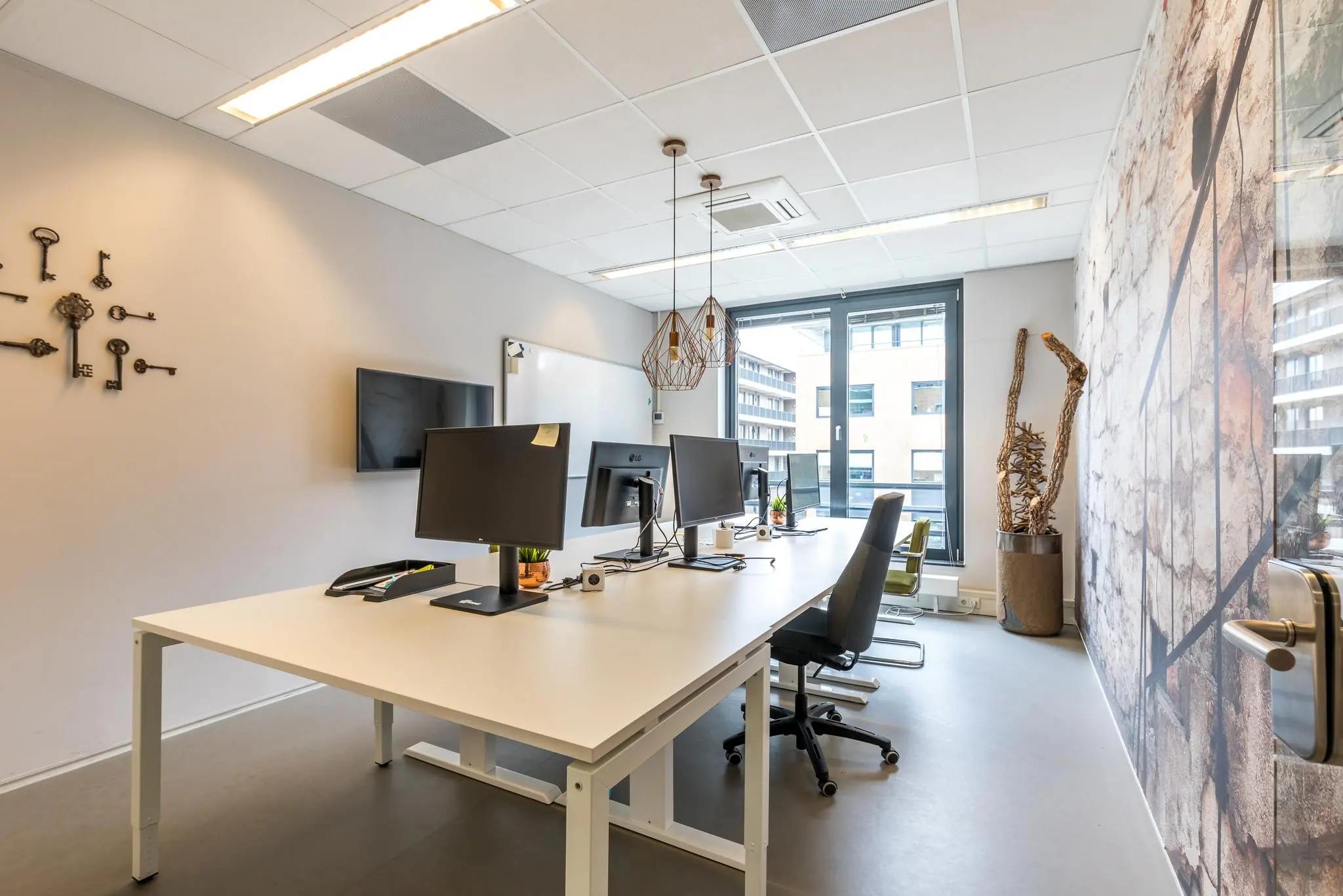 Moderne kantoorruimte aan de Coltbaan met meerdere bureaus, computerschermen, decoratieve elementen en grote ramen.