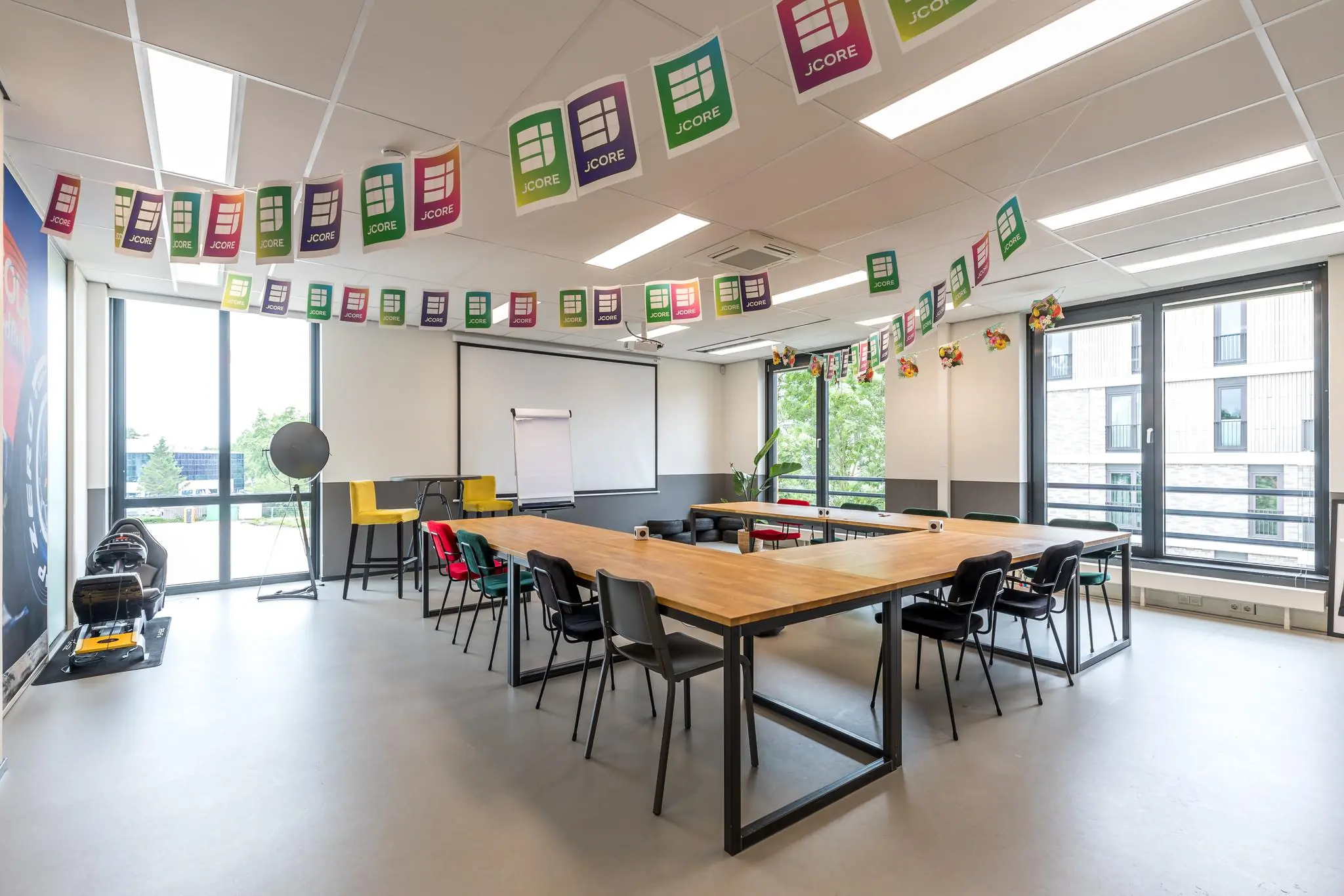 Moderne vergaderruimte aan de Coltbaan met U-vormige opstelling, JCore-versiering en grote ramen voor natuurlijk licht.