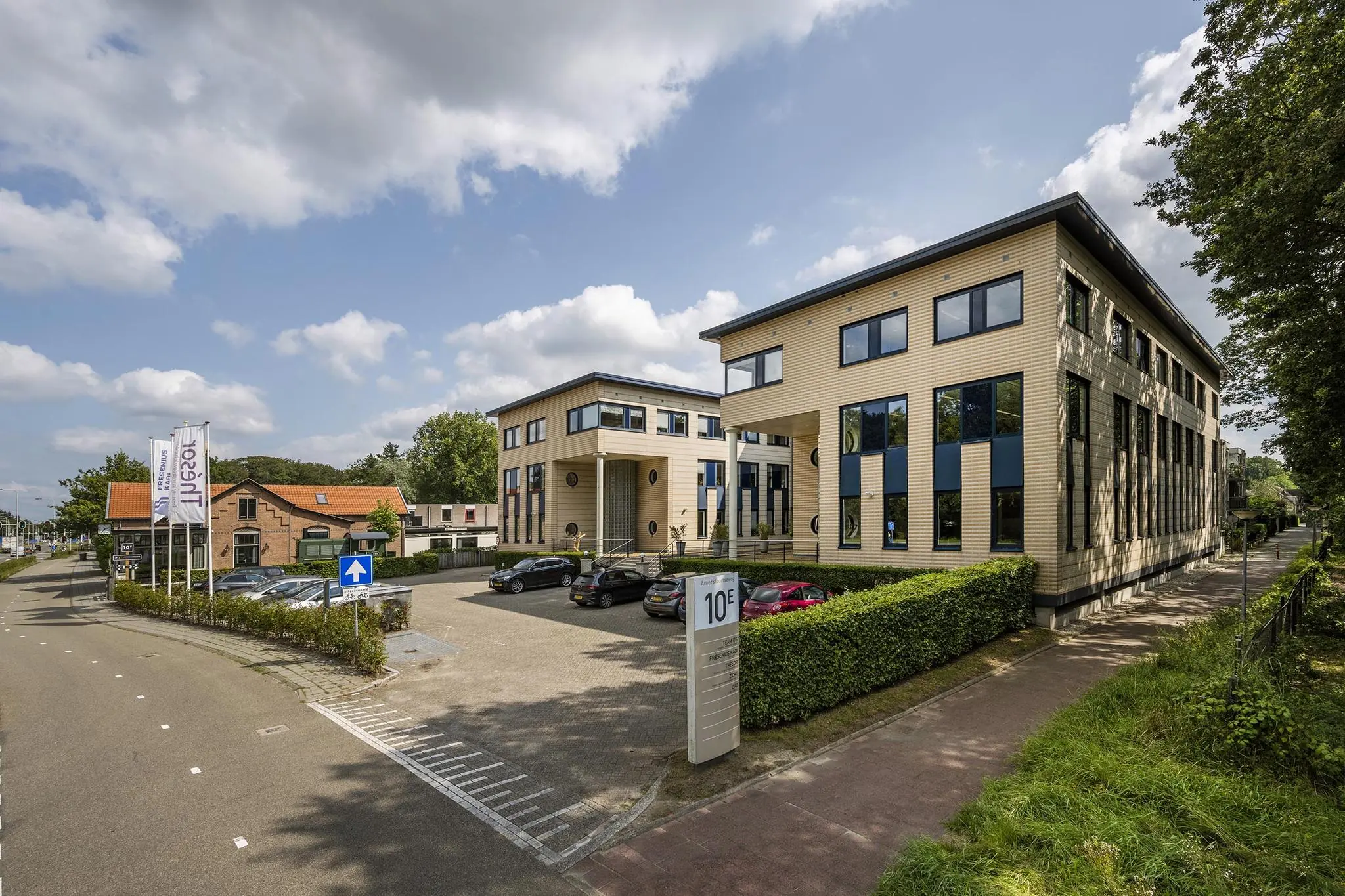 Modern kantoorgebouw aan de Amersfoortseweg met parkeerplaatsen en omliggend groen.