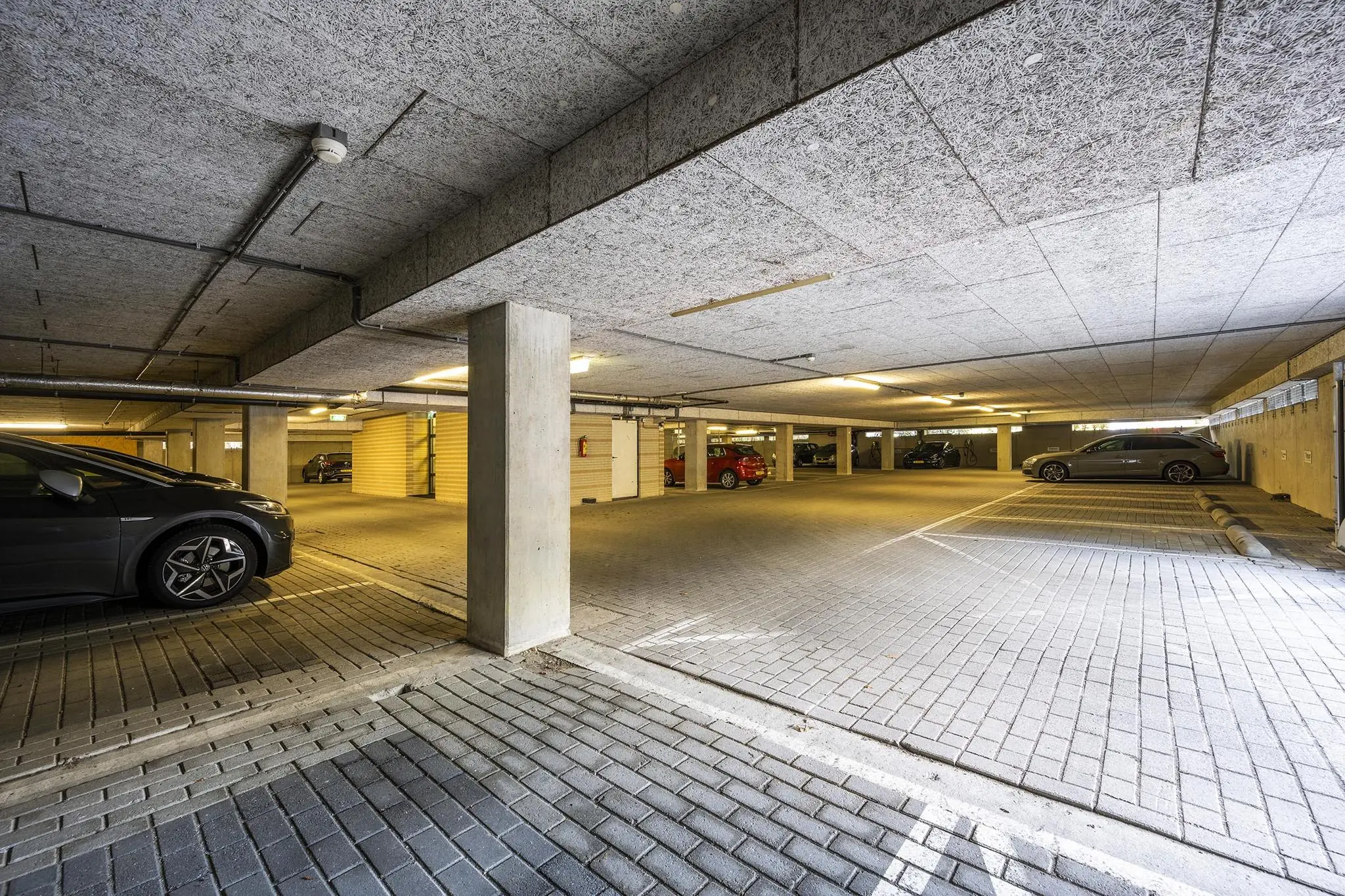 Ondergrondse parkeergarage aan de Amersfoortseweg met meerdere geparkeerde auto's en betonnen pilaren.