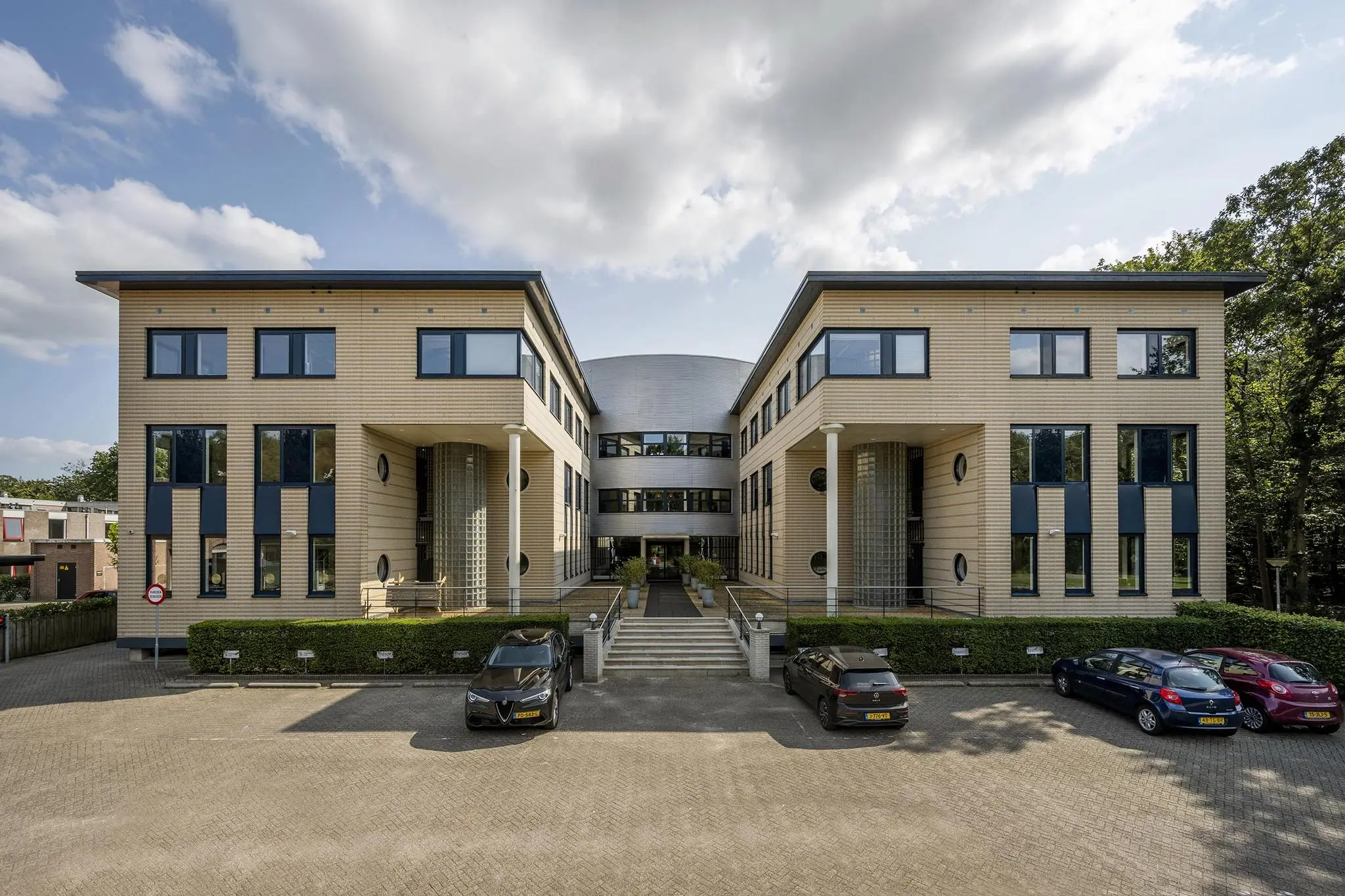 Modern kantoorgebouw aan de Amersfoortseweg met symmetrische architectuur en parkeergelegenheid aan de voorzijde.