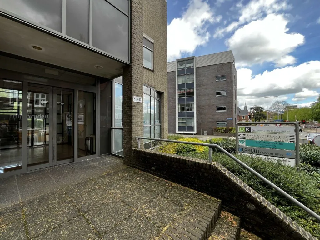 Ingang van een kantoorpand aan de Utrechtseweg met een bord waarop meerdere bedrijven staan vermeld.