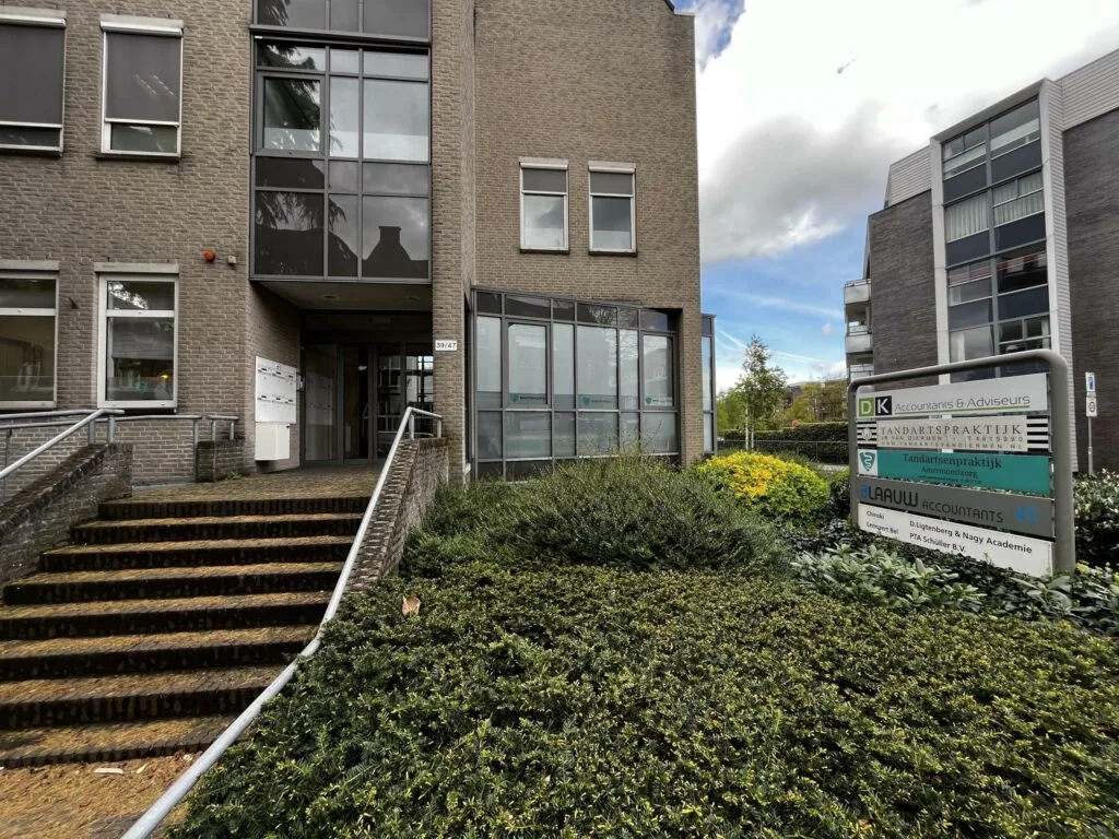 Ingang van een kantoorpand aan de Utrechtseweg met bord waarop meerdere bedrijven staan vermeld, waaronder een tandartspraktijk en accountantskantoor.