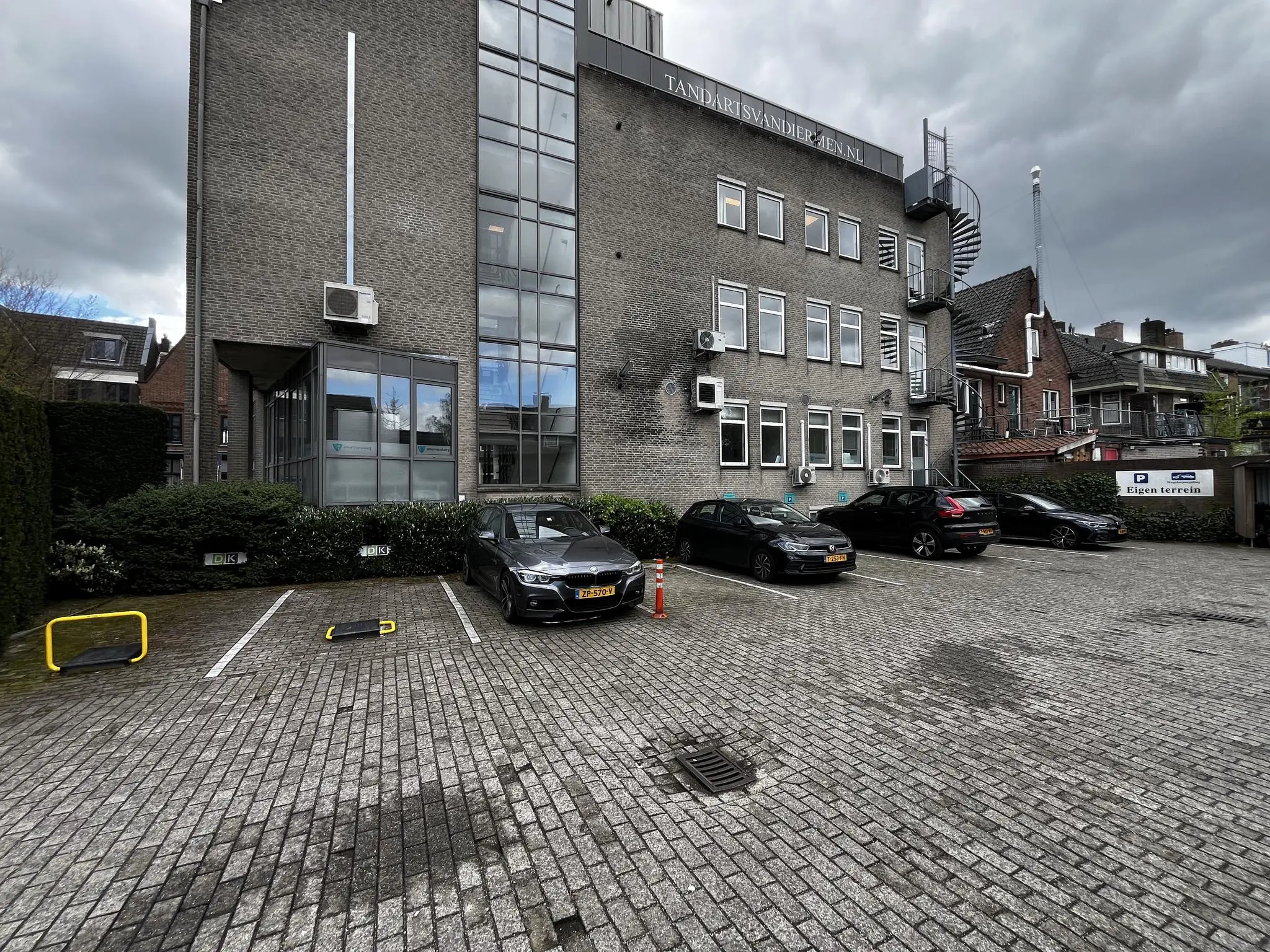 Parkeerterrein voor het gebouw van Tandarts Vanderzien aan de Utrechtseweg met meerdere geparkeerde auto’s.