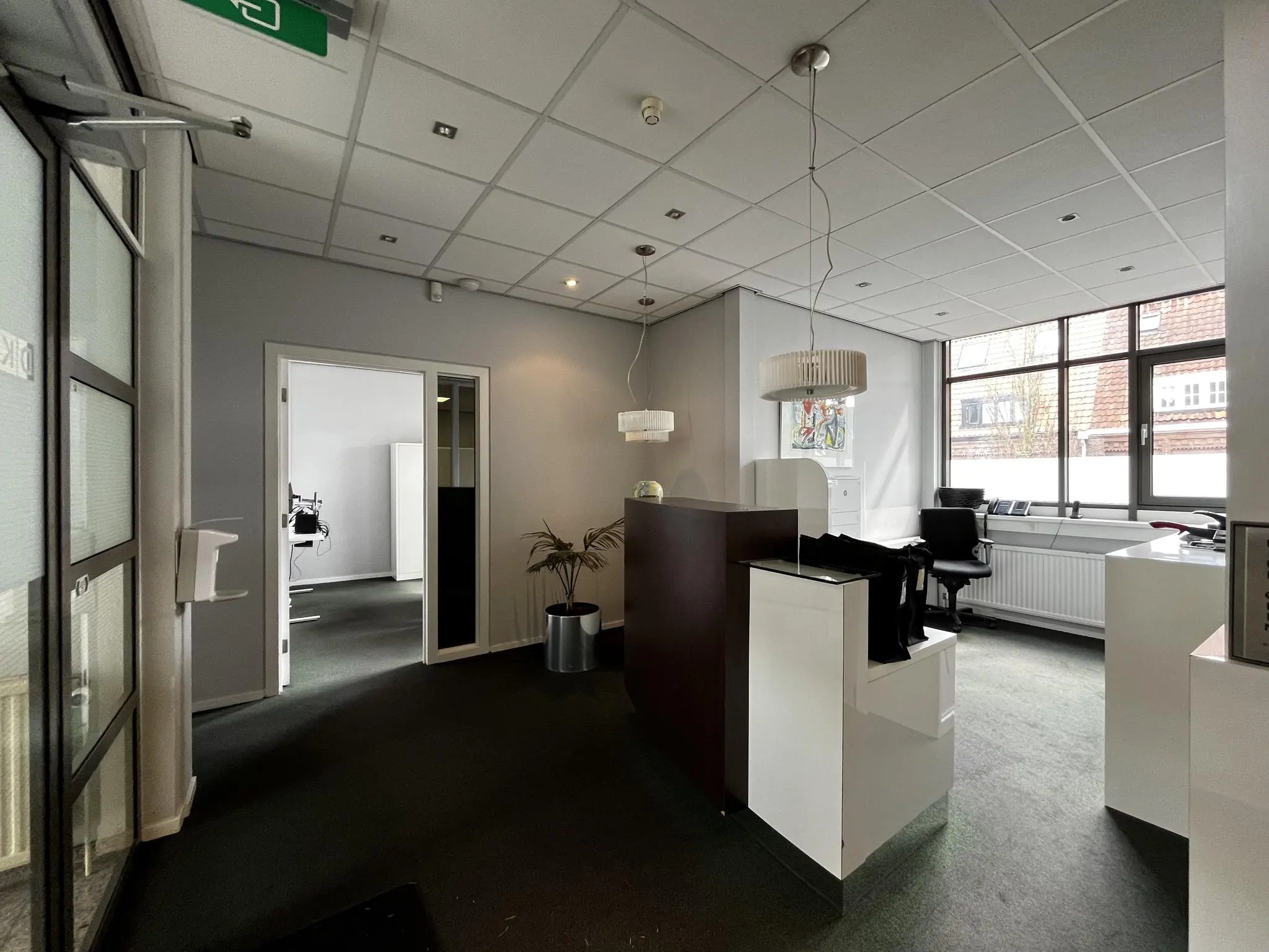 Moderne kantoorruimte aan de Utrechtseweg met receptiebalie, bureaus en grote ramen die zorgen voor veel daglicht.