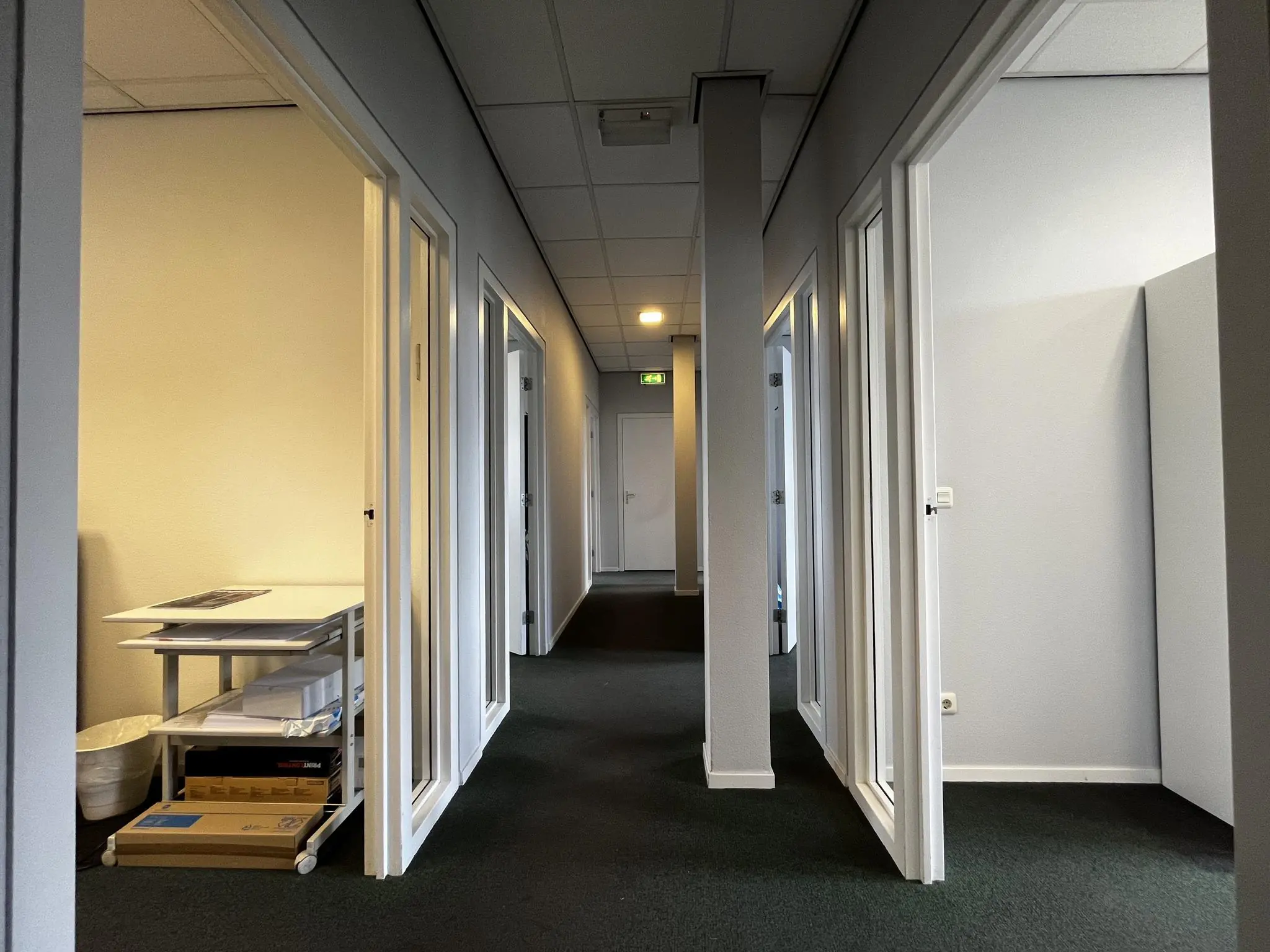 Gang met kantoordeuren en systeemplafond in een bedrijfsverzamelgebouw aan de Utrechtseweg.