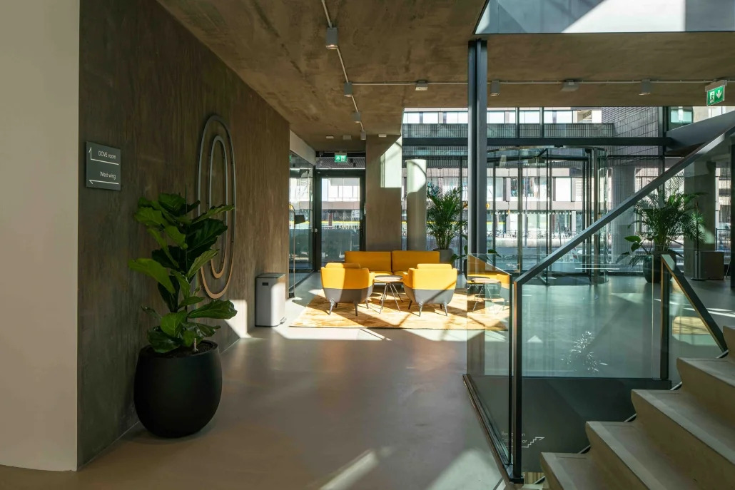 Moderne kantoorlobby aan de Catharijnesingel met gele zitbanken, glazen entree en veel daglicht.