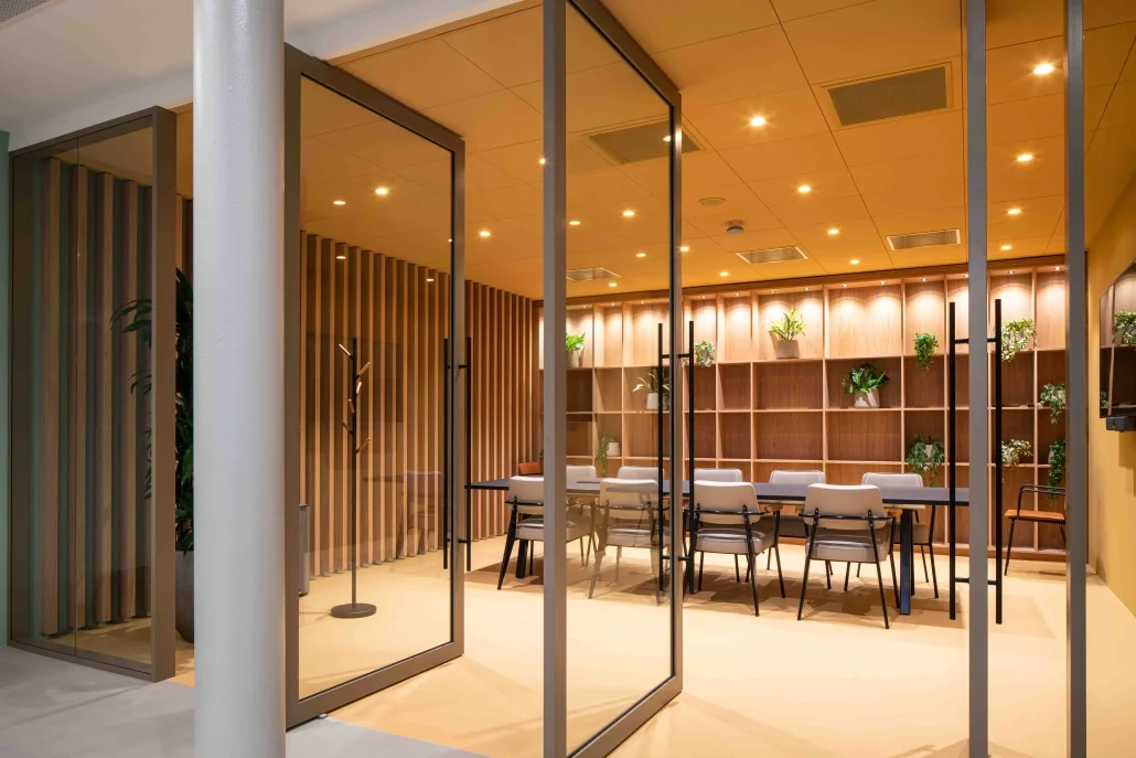Moderne vergaderruimte aan de Catharijnesingel met glazen wanden, houten accenten en een wandkast met planten.