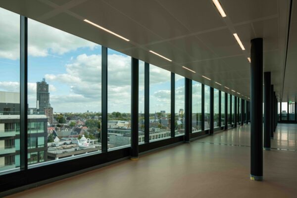 Uitzicht vanuit een modern kantoorgebouw aan de Catharijnesingel over de stad Utrecht met grote ramen en skyline op de achtergrond.