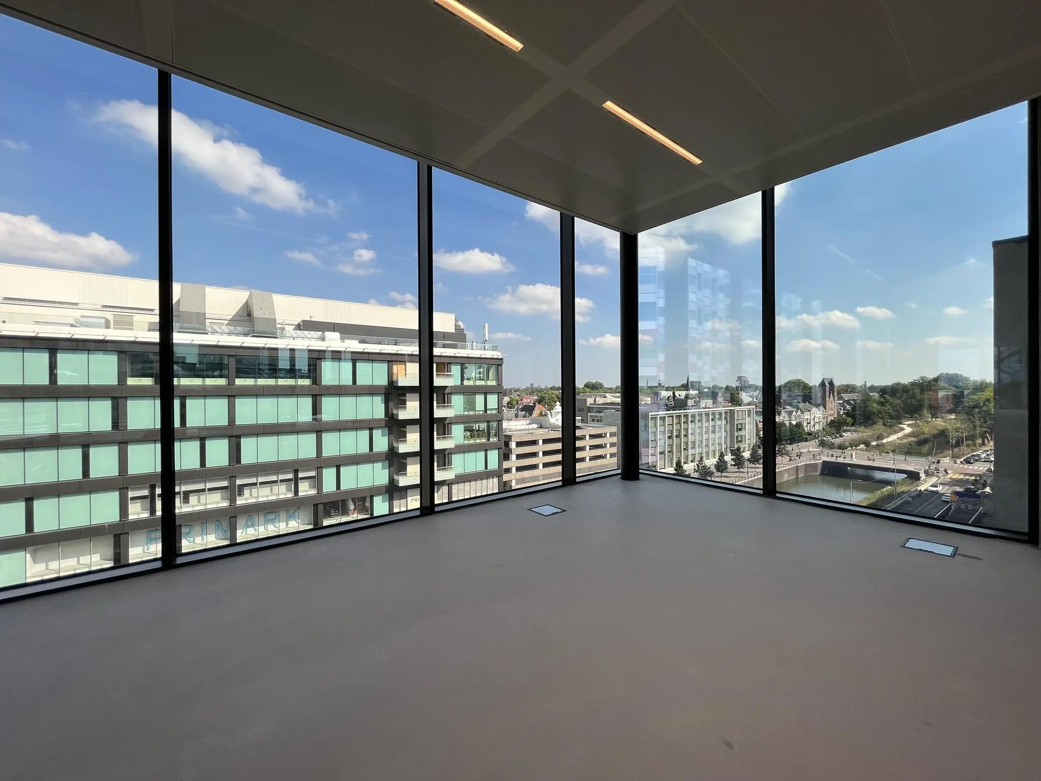 Uitzicht vanuit een lege kantoorruimte op de Catharijnesingel en omliggende gebouwen in Utrecht.