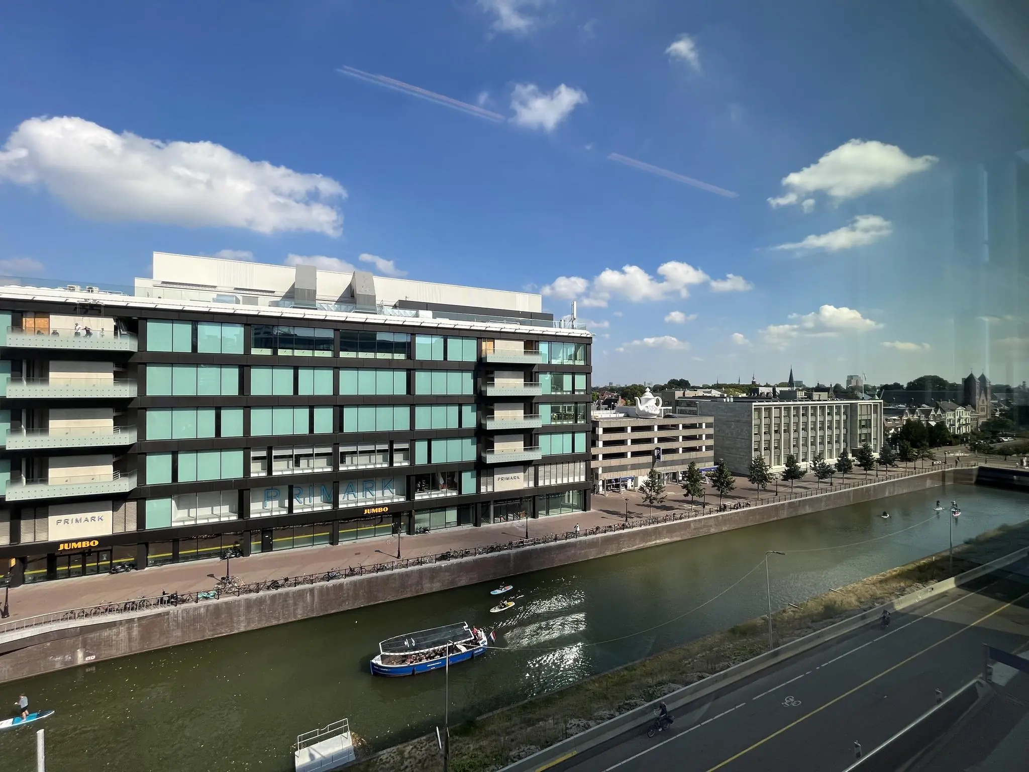 Uitzicht op de Catharijnesingel in Utrecht met het winkelpand van Primark en Jumbo langs het water.