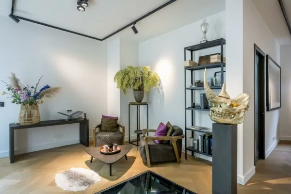 Stijlvol ingerichte zithoek aan de Lomanstraat met moderne meubels, opvallende decorstukken en planten.