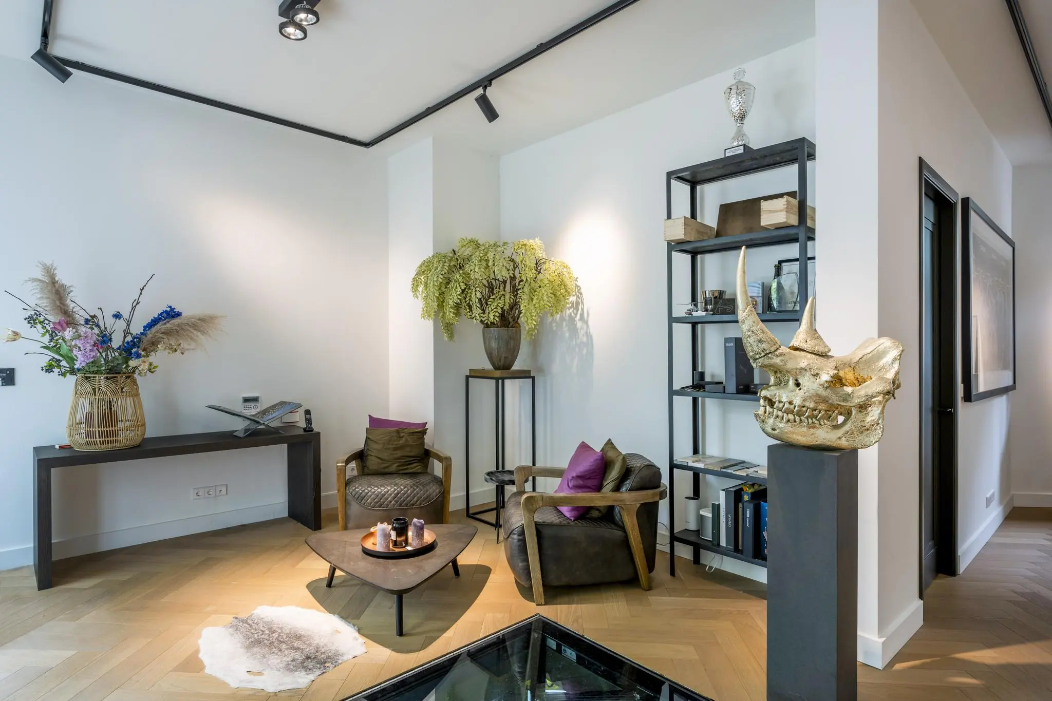 Stijlvol ingerichte zithoek aan de Lomanstraat met moderne meubels, opvallende decorstukken en planten.