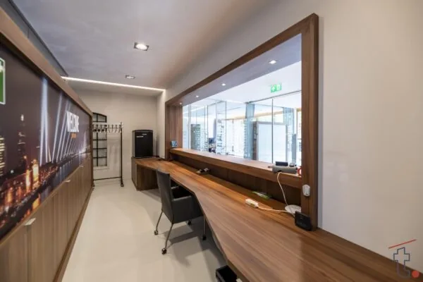 Receptiebalie met houten werkblad en glazen wand in een modern kantoor aan de Charloisse Lagedijk.