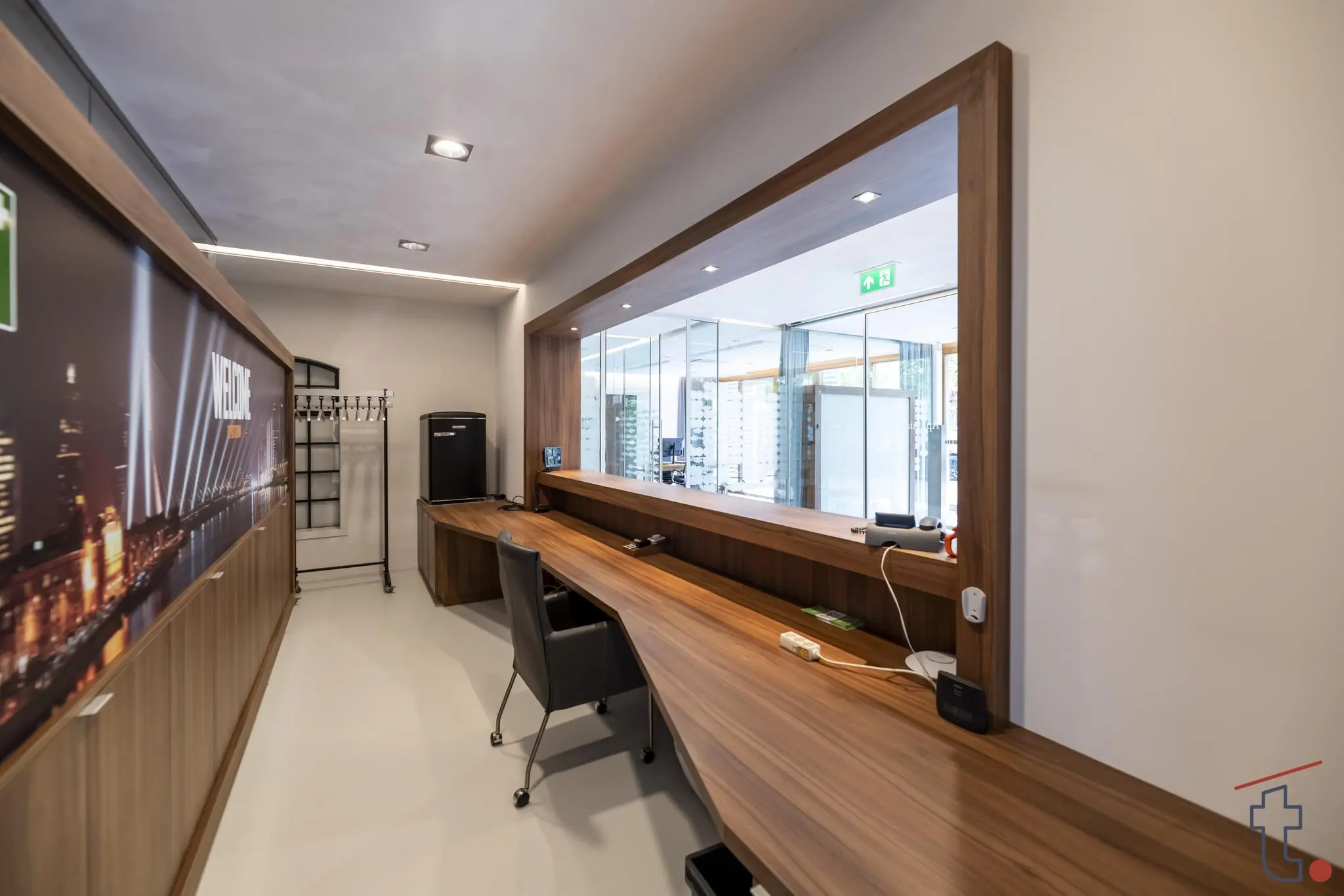 Receptiebalie met houten werkblad en glazen wand in een modern kantoor aan de Charloisse Lagedijk.