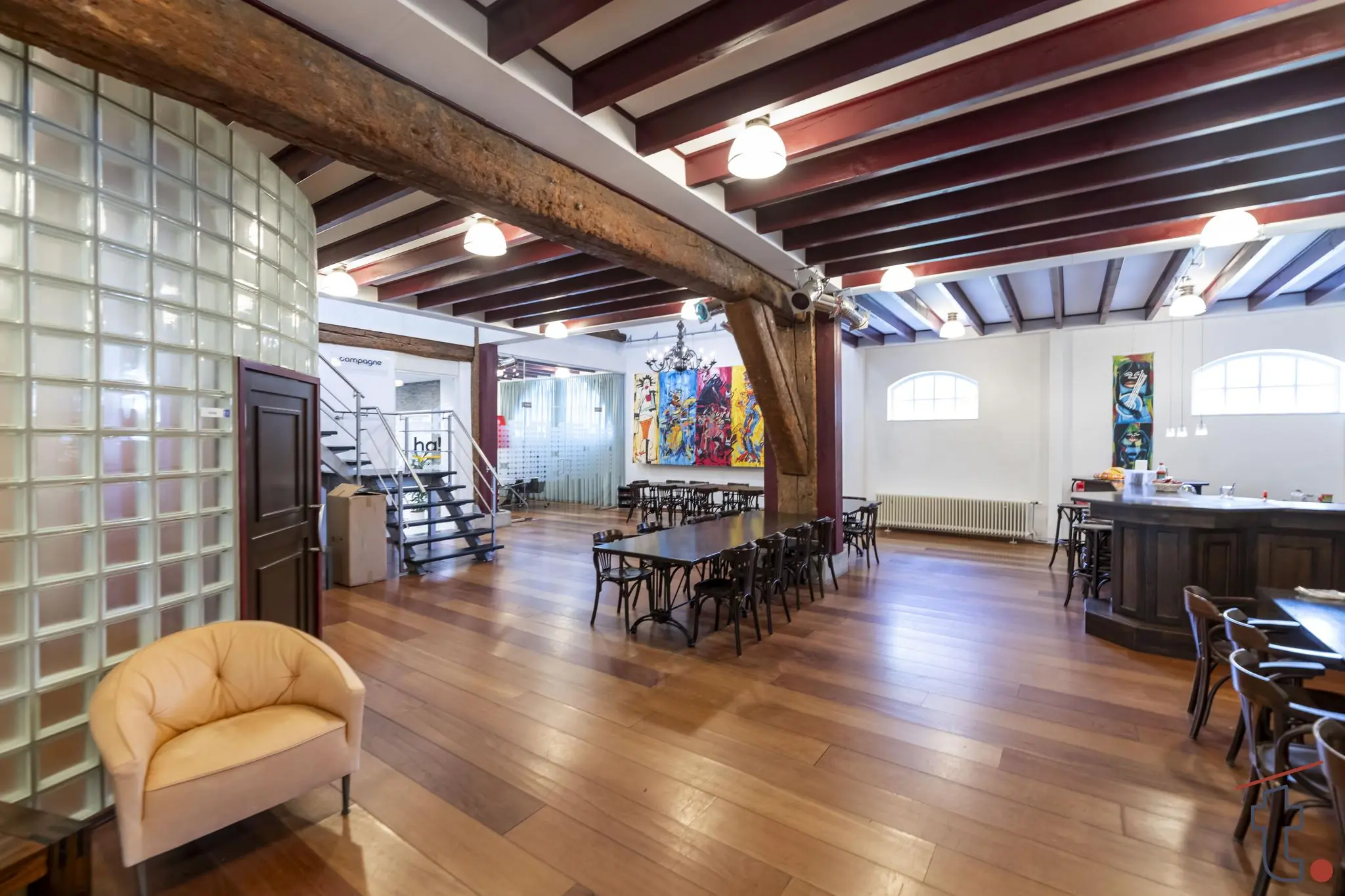 Modern ingerichte ruimte aan de Charloisse Lagedijk met houten vloer, glasblokkenwand, kunst aan de muur en zichtbare houten balken.