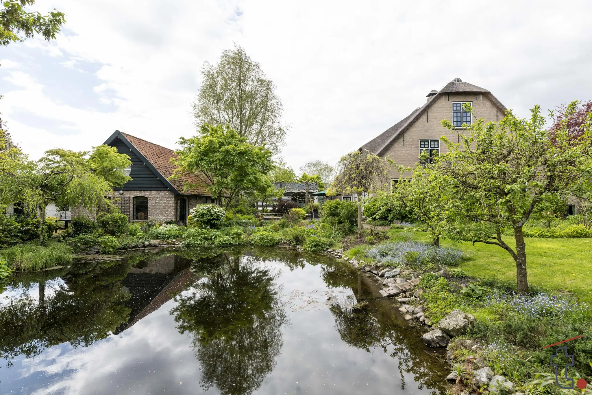 Boerderij aan de Charloisse Lagedijk met weelderige tuin en vijver op de voorgrond.