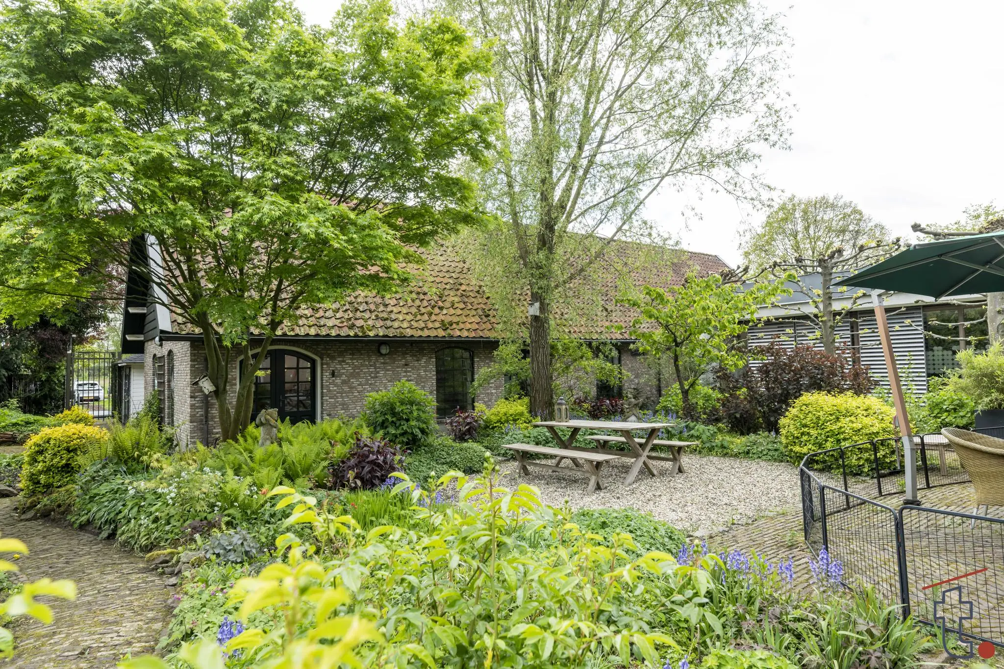 Groene en weelderige tuin met picknicktafel, gelegen bij een gerenoveerde boerderij aan de Charloisse Lagedijk.