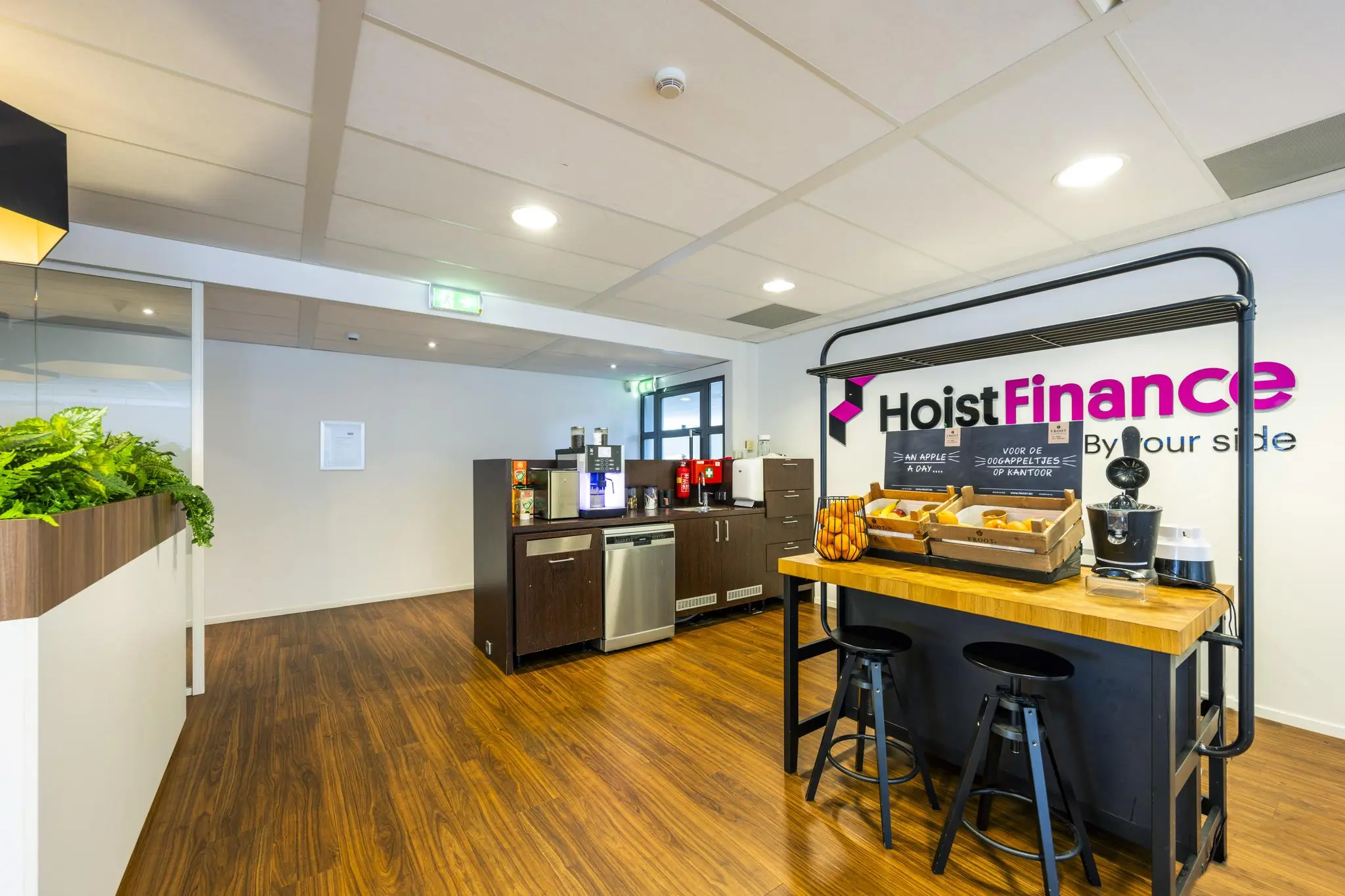Moderne pantryruimte bij Hoist Finance met koffieapparaten, fruit en snacks op Amstelveenseweg.