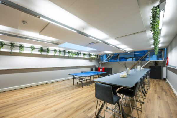Moderne vergaderruimte aan de Herengracht met lange tafel, tafeltennistafel en hangende planten.