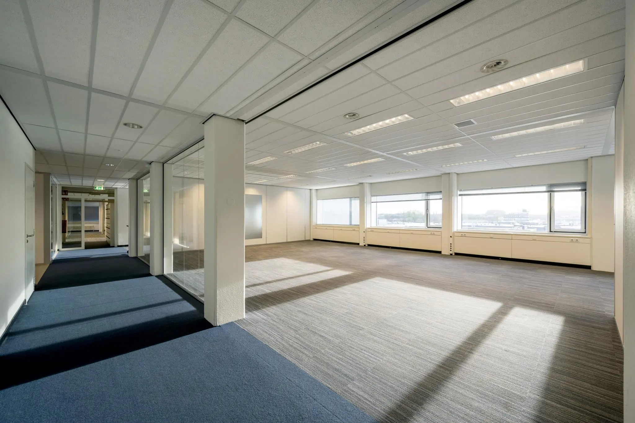 Licht en ruim kantoorpand aan de Spaklerweg met grote ramen en glazen scheidingswanden.