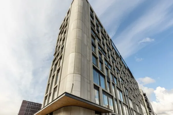 Modern kantoorgebouw aan de Rijnhavenkade met strakke gevel en grote ramen tegen een blauwe lucht.