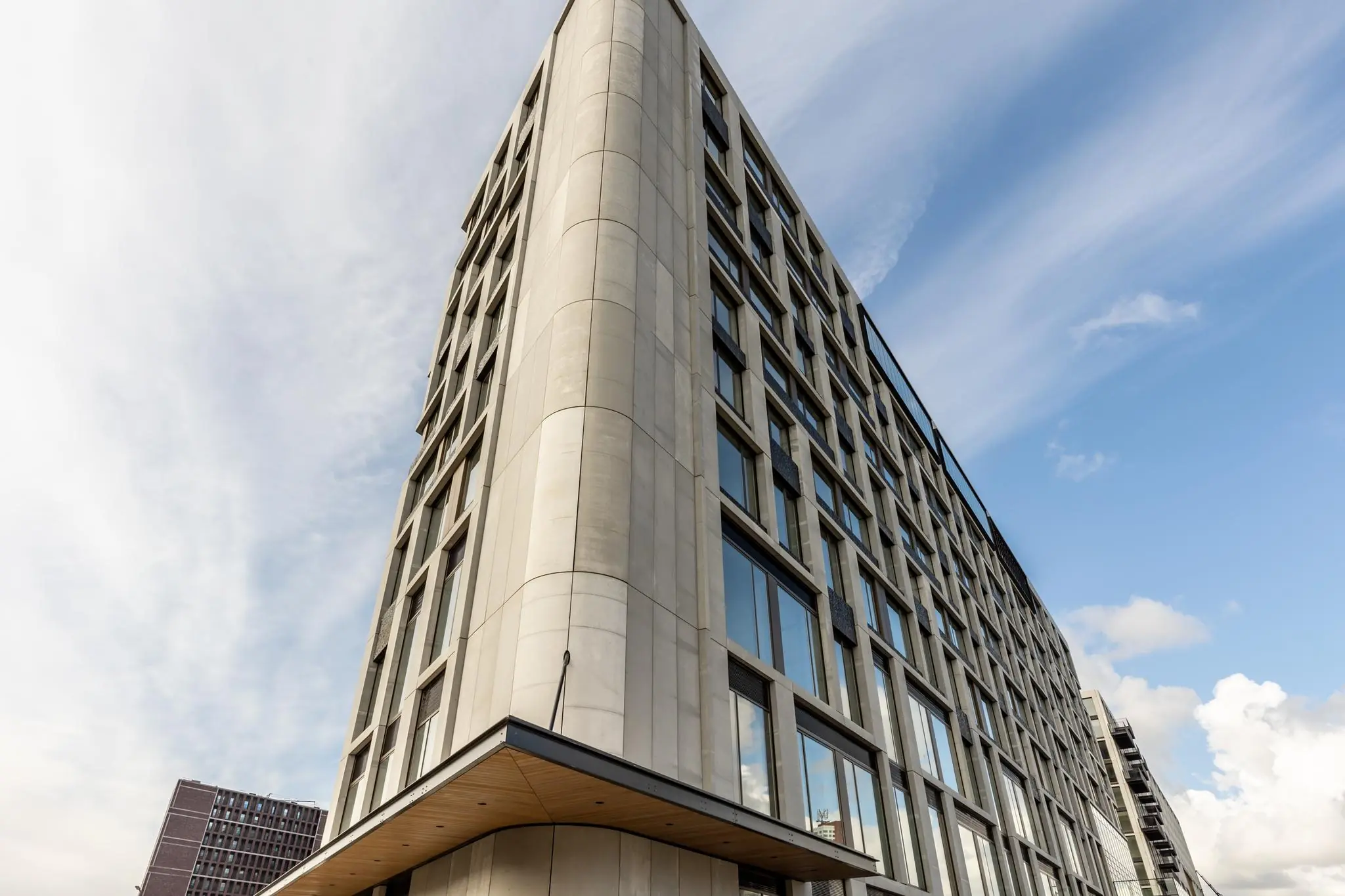 Modern kantoorgebouw aan de Rijnhavenkade met strakke gevel en grote ramen tegen een blauwe lucht.