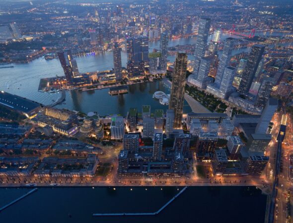 Luchtfoto van de Rijnhavenkade in Rotterdam bij avondschemering met verlichte hoogbouw en stadsontwikkeling langs het water.