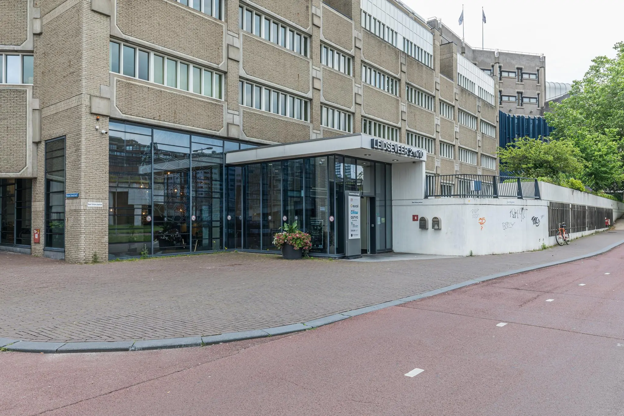 Ingang van het kantoorgebouw Leidseveer 2-10 in Utrecht met grote glazen gevel en straatzicht.