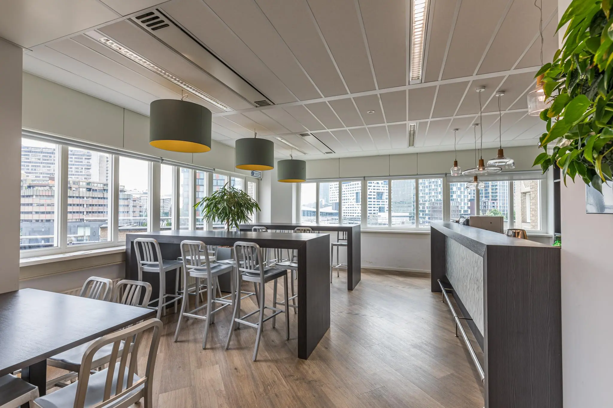 Moderne zithoek met hoge tafels en uitzicht op het Leidseveer in Utrecht.