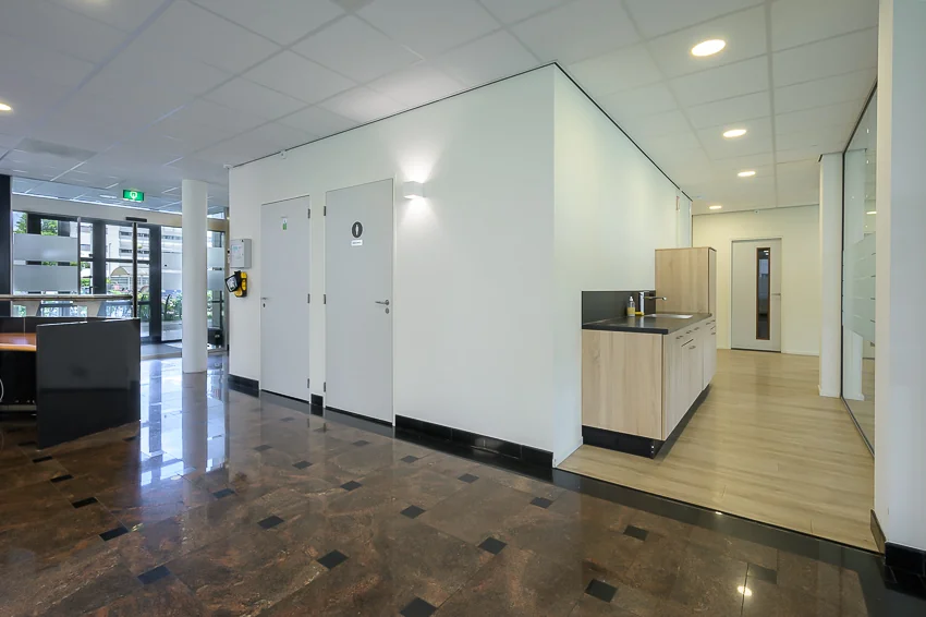 Modern kantoorpand aan de Rivium Westlaan met een kitchenette, toiletruimte en glanzende tegelvloer.