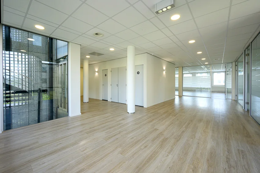 Moderne, lichte kantoorruimte aan de Rivium Westlaan met glazen wanden en houten vloer.
