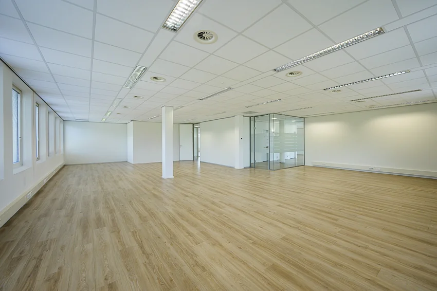 Lichte, ruime en moderne kantoorruimte aan de Rivium Westlaan met glazen vergaderruimte en houten vloer.