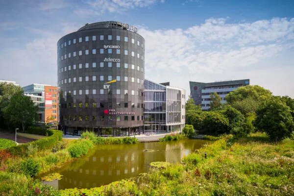 Kantoorcomplex Yin Yang aan de Euclideslaan in Utrecht, omgeven door groen en een vijver op de voorgrond.