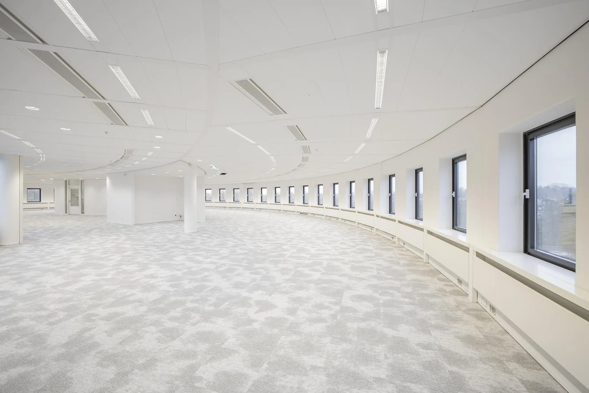 Licht en ruim kantoorpand aan de Euclideslaan met gebogen wand en grote ramen.