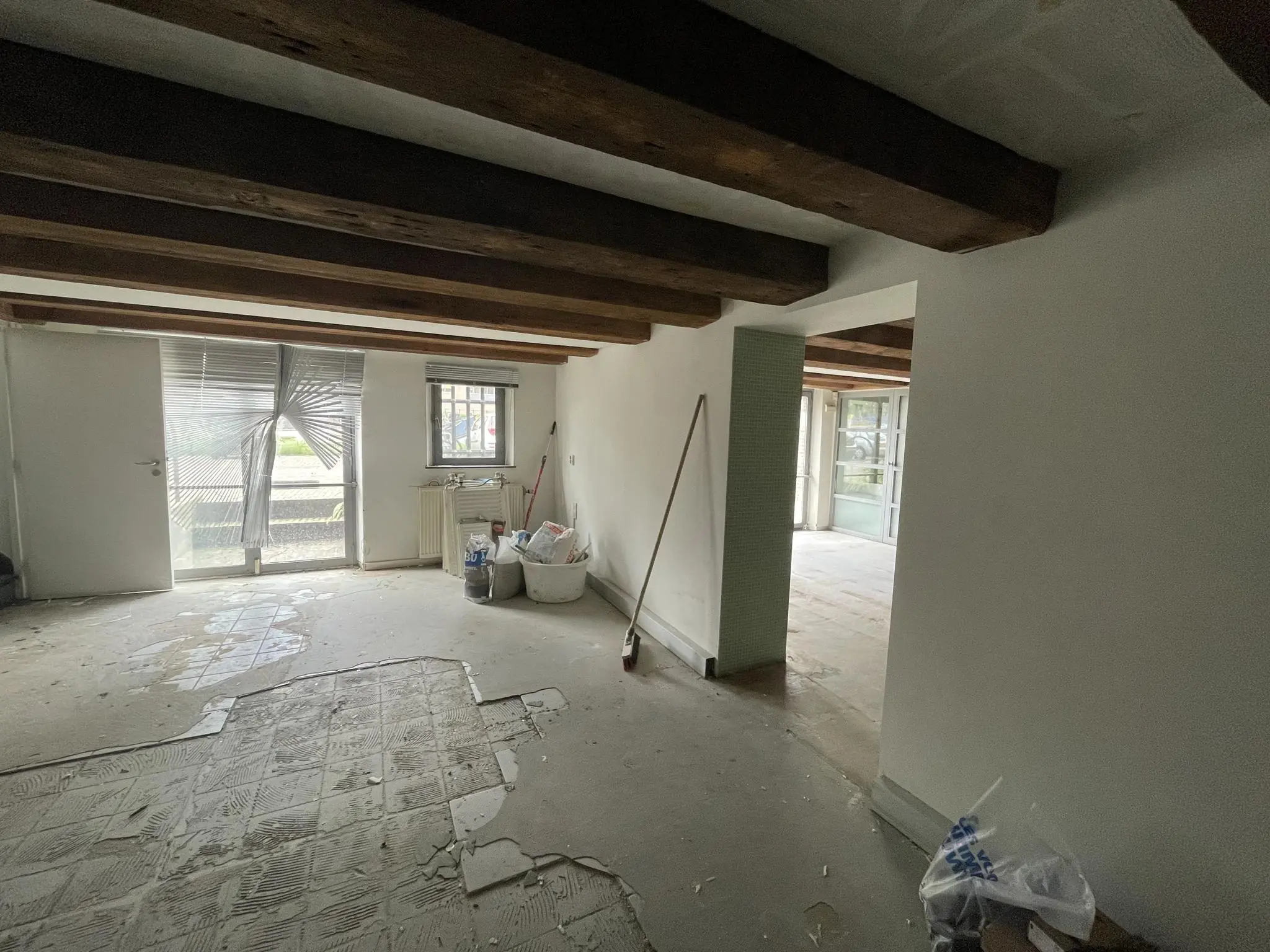 Een leegstaand appartement aan het Entrepotdok met zichtbare waterschade en renovatiematerialen op de vloer.