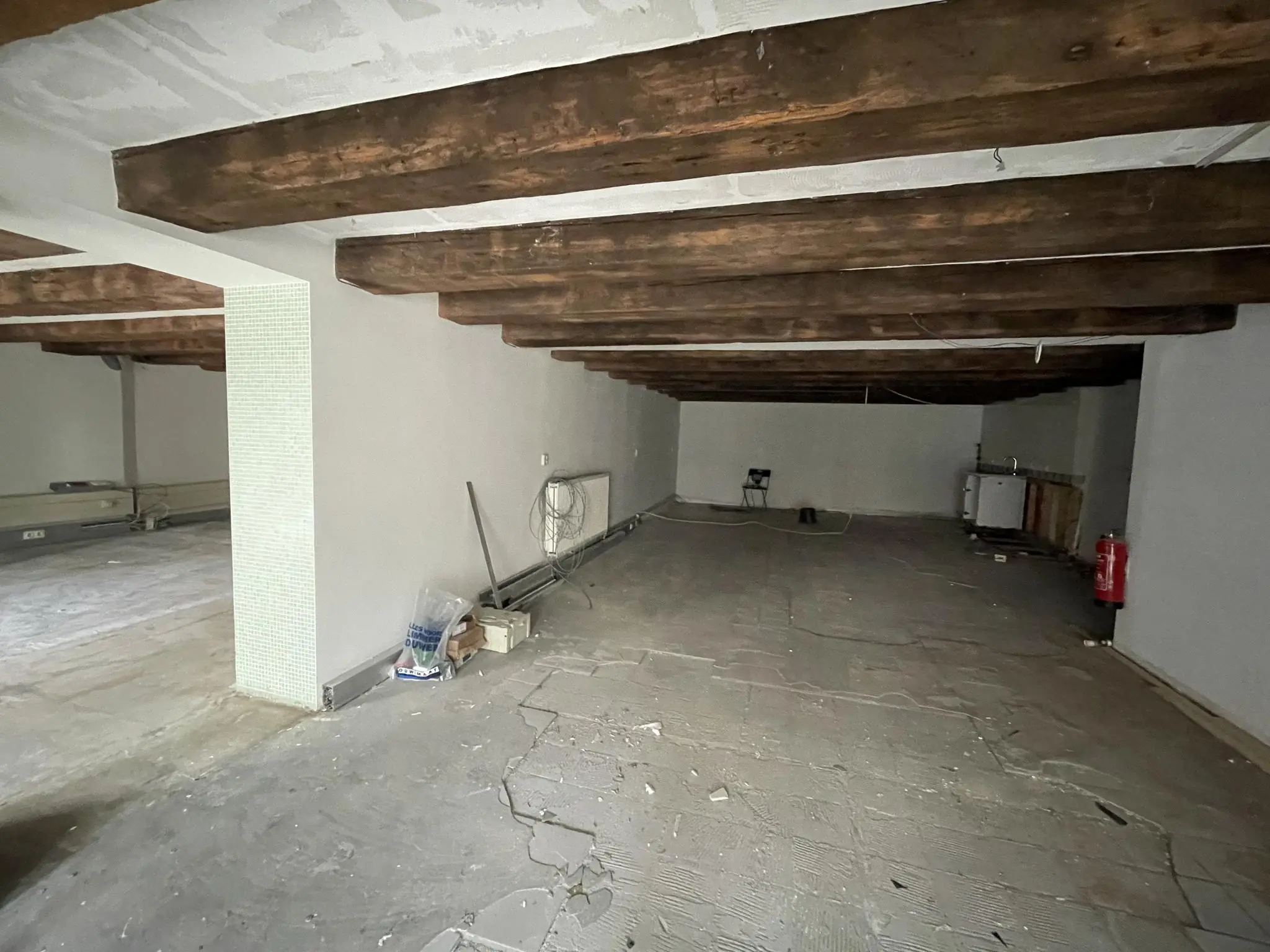 Lege ruimte in een kelder met houten balkenplafond aan het Entrepotdok, deels in renovatie.