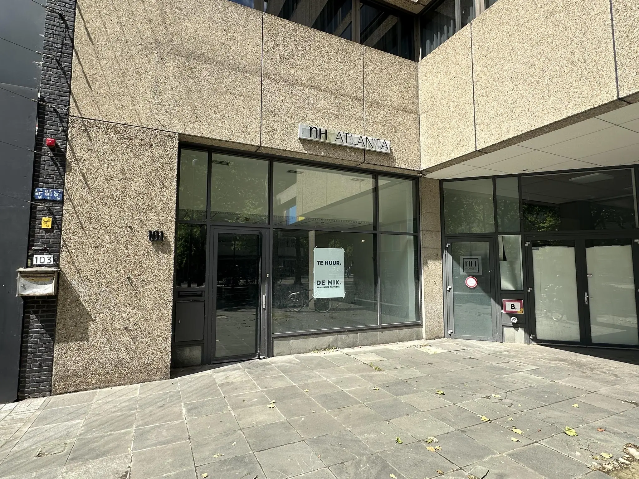 Vooraanzicht van een leegstaand winkelpand aan de Coolsingel 101 in Rotterdam met een "Te huur" poster op het raam.