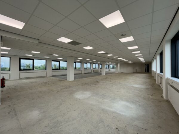 Leegstaande kantoorruimte met systeemplafond en grote ramen aan de Nevelgaarde.