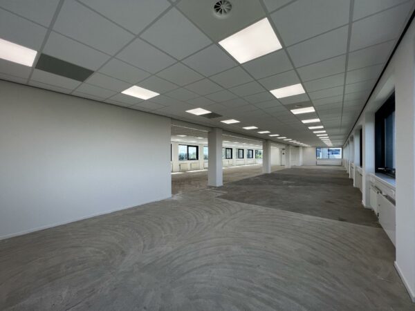 Leeg kantoorpand aan de Nevelgaarde met systeemplafond, raamkozijnen en onafgewerkte vloer.