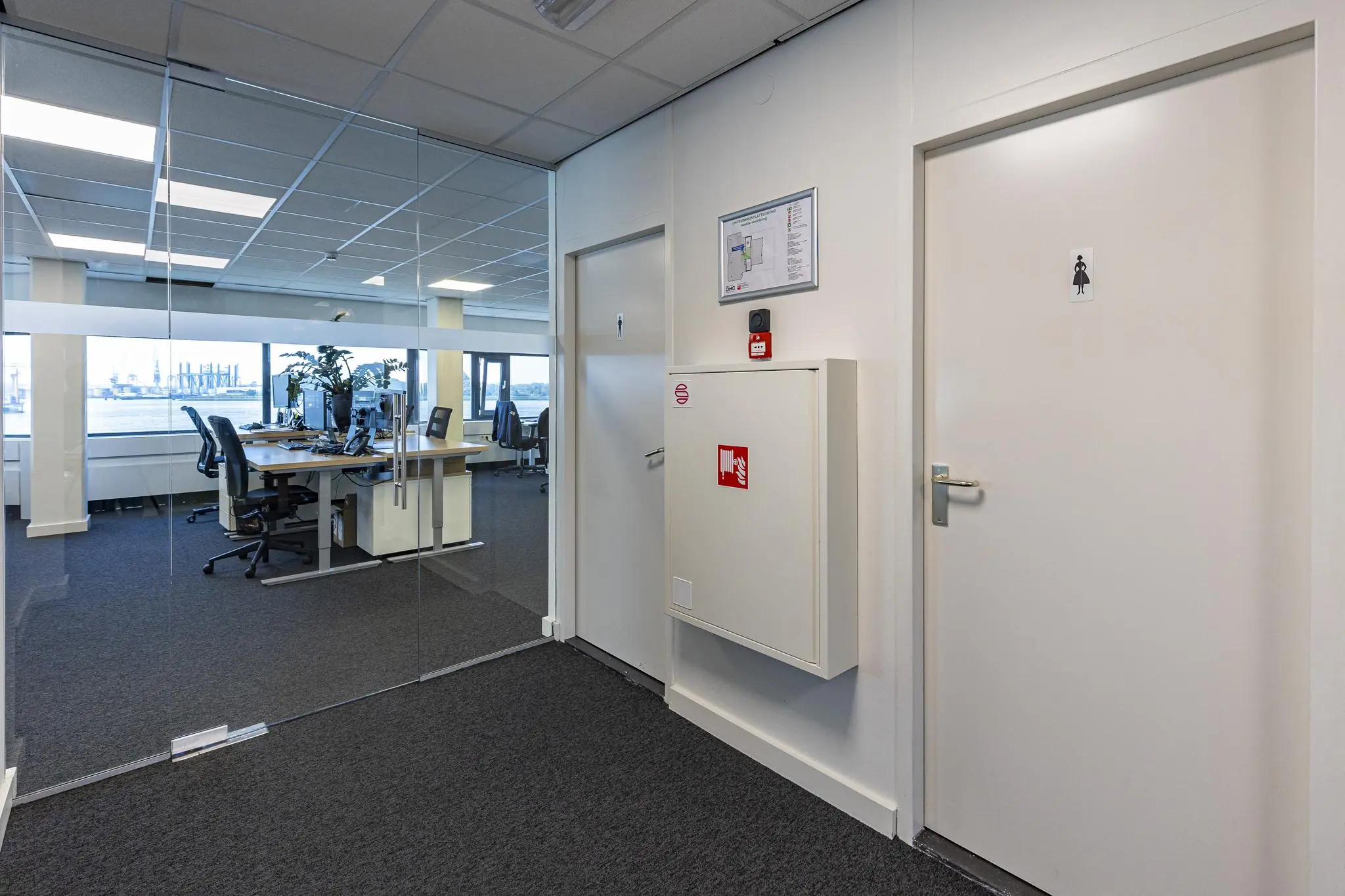 Kantoorruimte aan de Havenstraat met glazen vergaderruimte, brandblusvoorziening en toiletten.