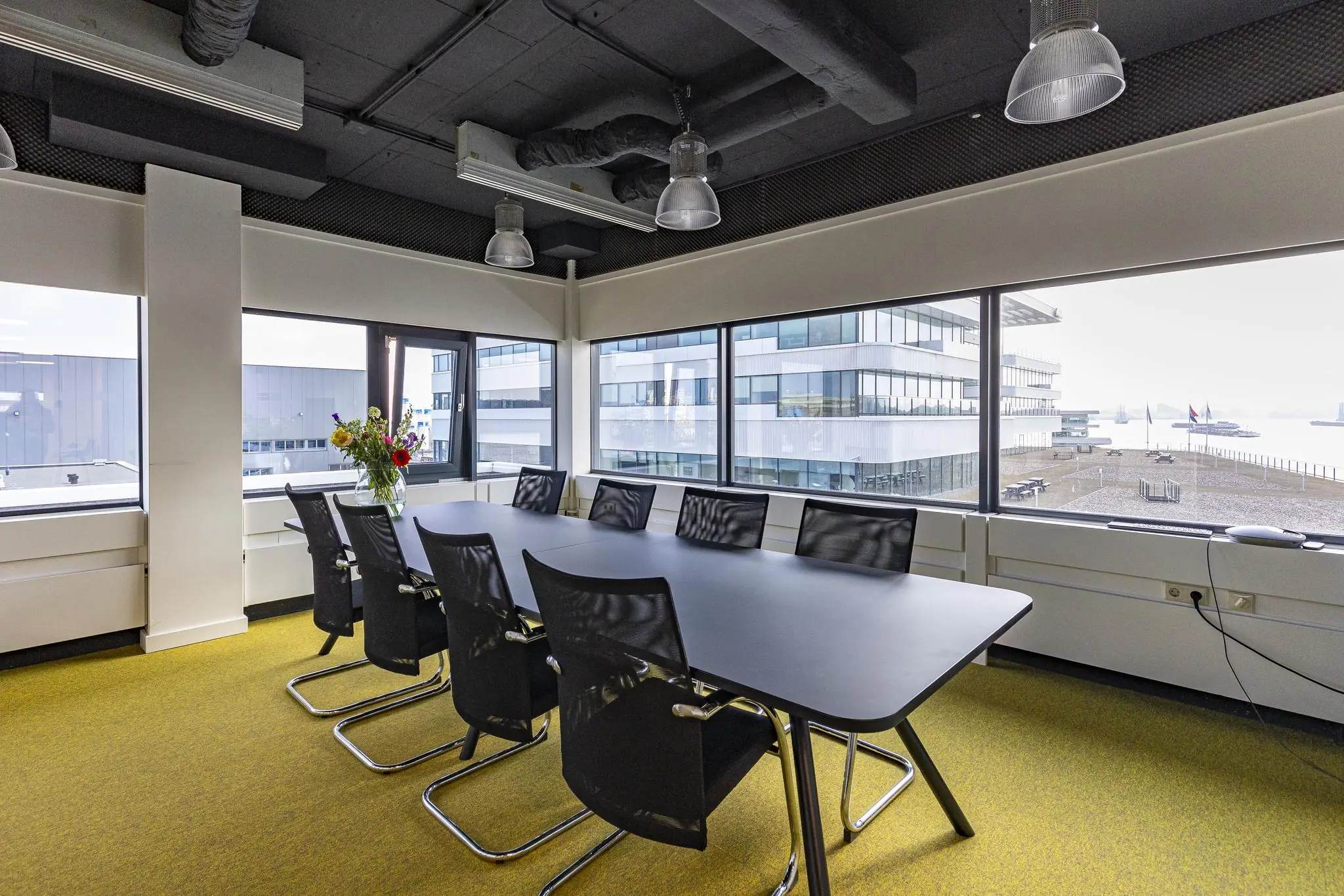 Vergaderruimte met moderne inrichting en uitzicht op het havengebied aan de Havenstraat.